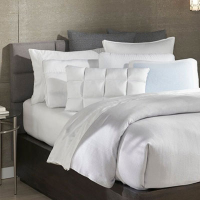 A super big comfy plush bed with white bedding and sheets